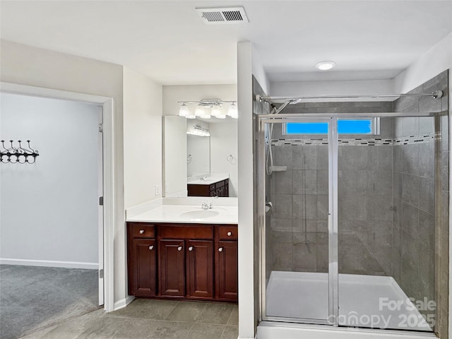 bathroom featuring vanity, a shower with shower door, and tile patterned floors