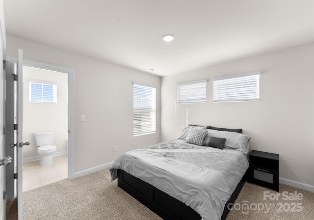 bedroom with light carpet and connected bathroom