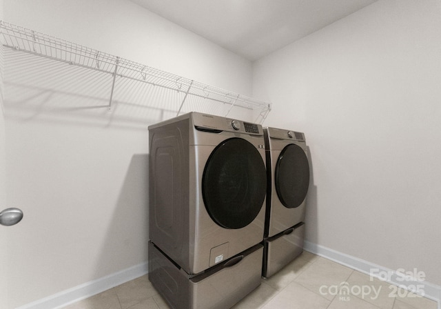 laundry room with washing machine and dryer and light tile patterned floors