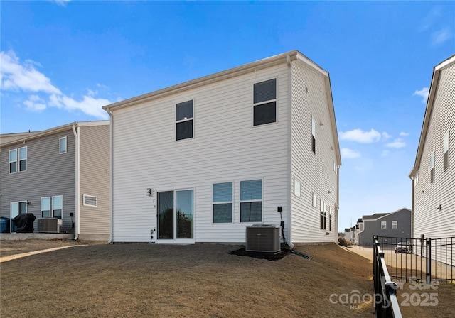 back of property featuring a yard and central AC