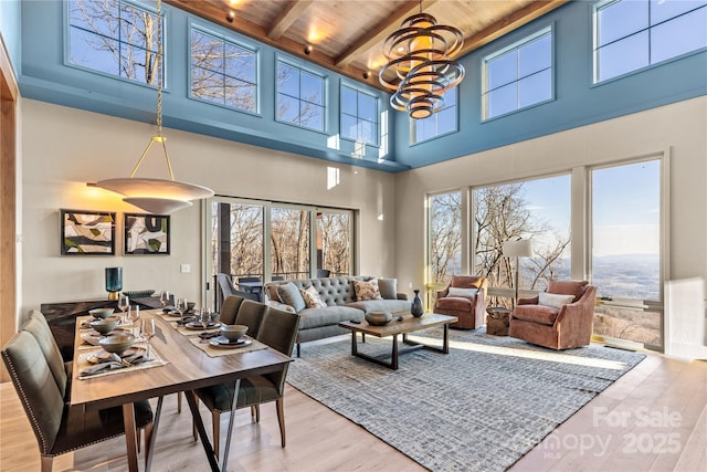 living room with a notable chandelier, wooden ceiling, light hardwood / wood-style floors, and beamed ceiling