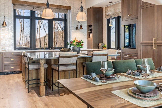 dining area featuring a towering ceiling and light wood-style floors