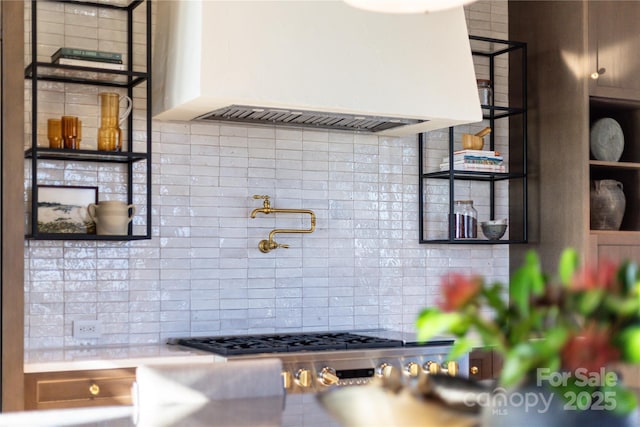 kitchen featuring decorative backsplash, light countertops, and custom exhaust hood