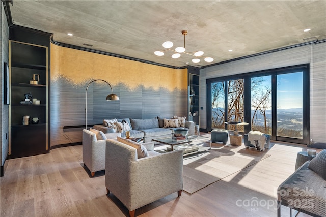 living room with a chandelier, built in shelves, and wood finished floors