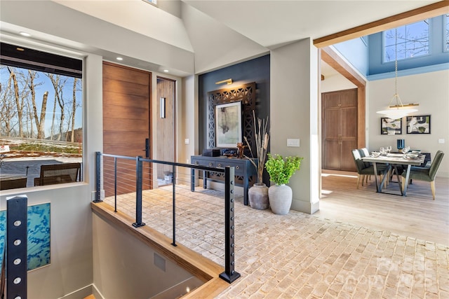 foyer entrance with brick floor and a towering ceiling