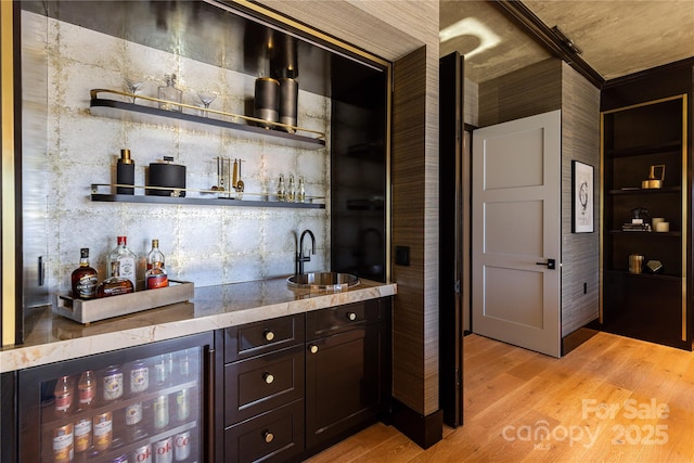 bar with sink, wine cooler, and light hardwood / wood-style flooring