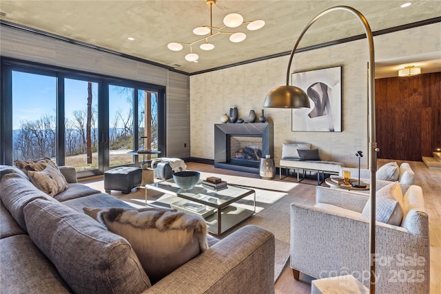 living room with crown molding, a fireplace, and wood finished floors