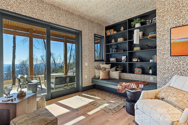 sitting room featuring wallpapered walls and wood finished floors