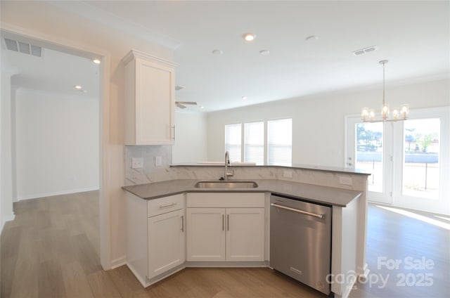 kitchen with sink, stainless steel dishwasher, plenty of natural light, decorative backsplash, and white cabinets