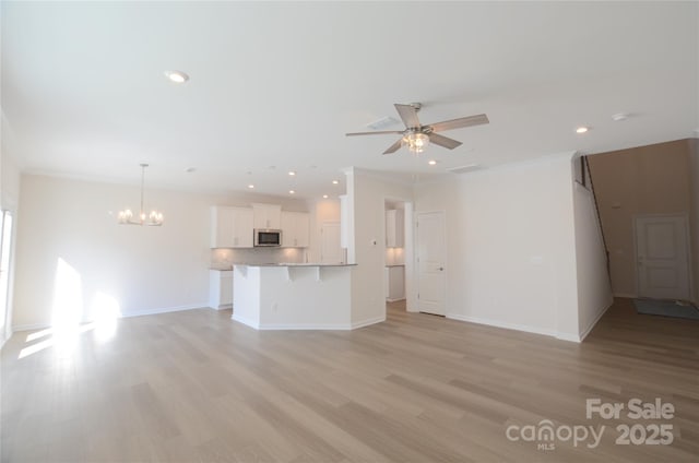 unfurnished living room with crown molding, ceiling fan with notable chandelier, and light hardwood / wood-style floors