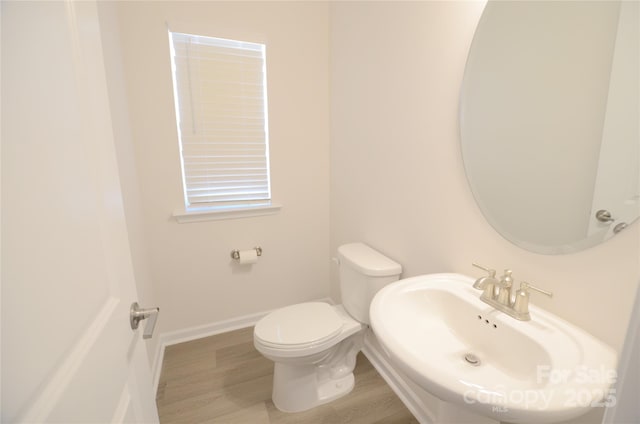 bathroom with toilet, sink, and hardwood / wood-style floors