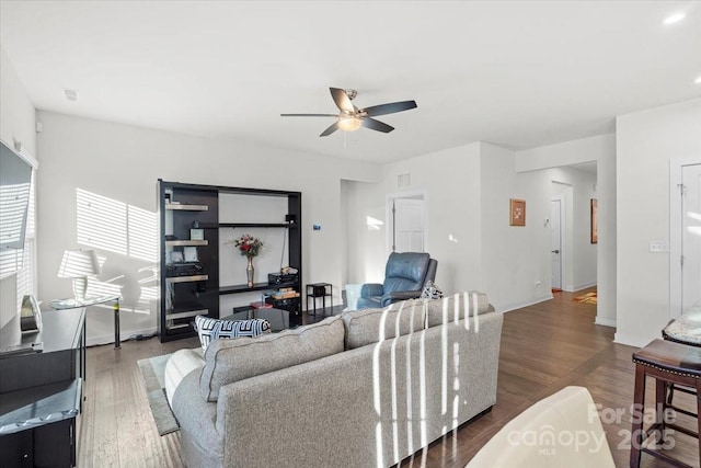 living room featuring dark wood-type flooring and ceiling fan