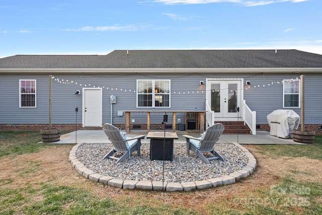 rear view of property with french doors, a yard, a patio area, and an outdoor fire pit