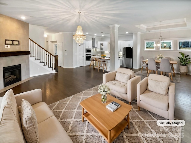 living room with an inviting chandelier, ornamental molding, and dark hardwood / wood-style floors