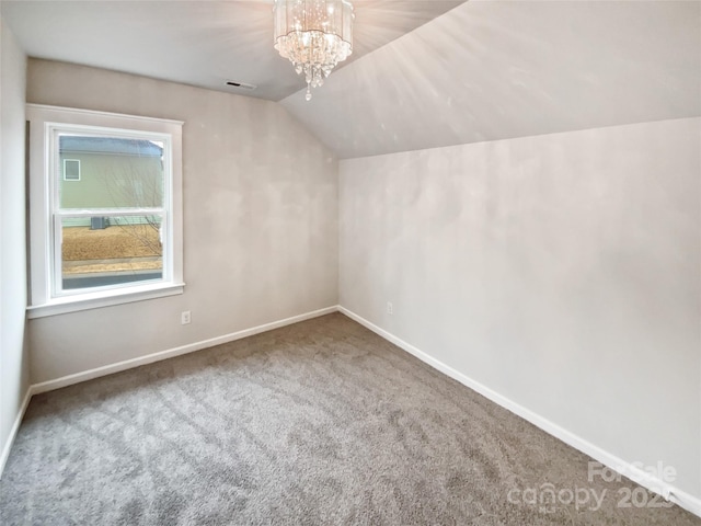 additional living space featuring carpet floors, a chandelier, and vaulted ceiling