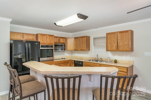 kitchen with ornamental molding, a kitchen bar, sink, and black appliances