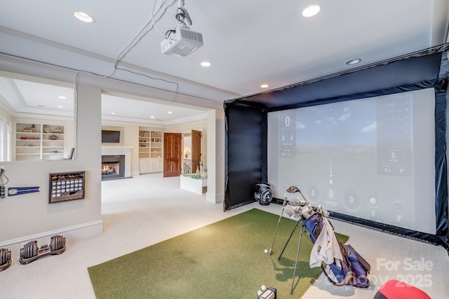 rec room with golf simulator, built in shelves, crown molding, and carpet