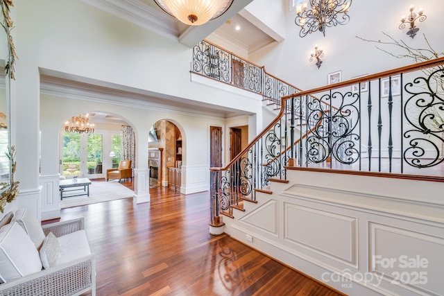 entrance foyer with hardwood / wood-style floors, a towering ceiling, and a chandelier