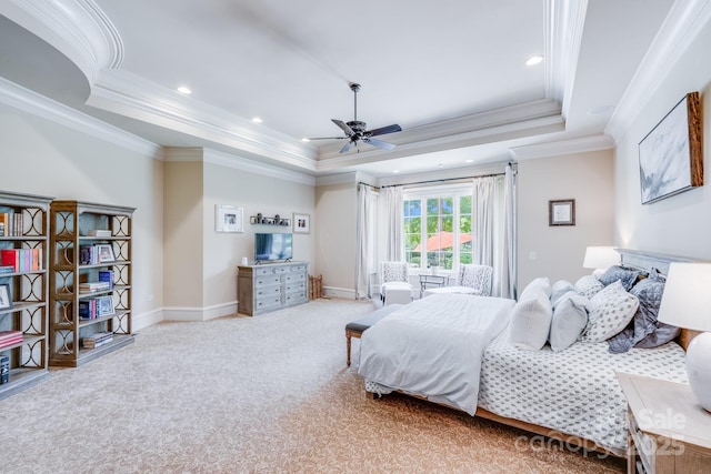 carpeted bedroom with a raised ceiling, crown molding, and ceiling fan