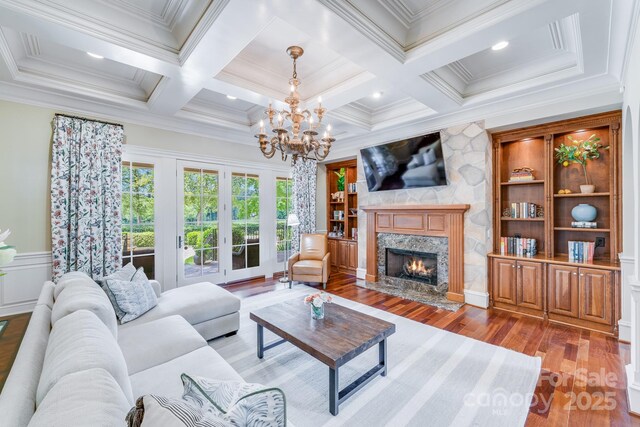 living room featuring ornamental molding, built in features, and a fireplace