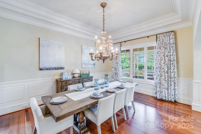 dining space with crown molding, dark wood-type flooring, and a notable chandelier