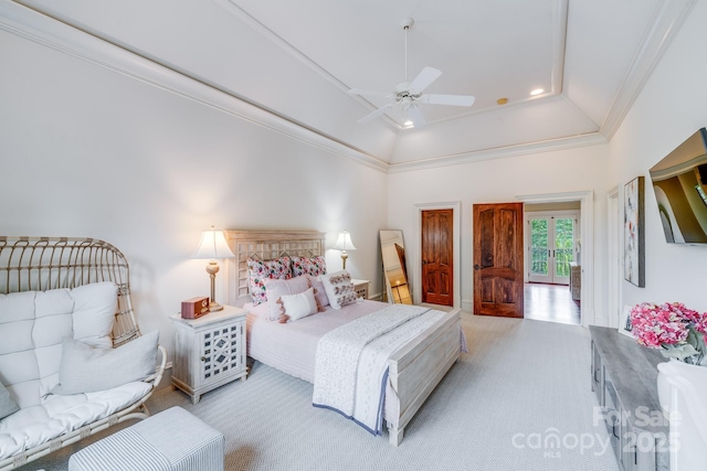 bedroom featuring ornamental molding, light carpet, ceiling fan, and a tray ceiling