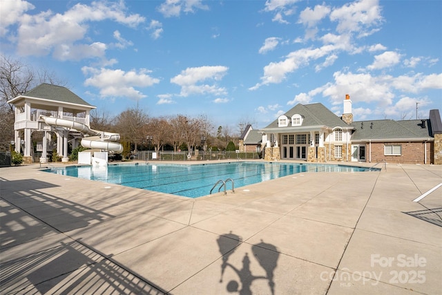 view of pool featuring a water slide and a patio area