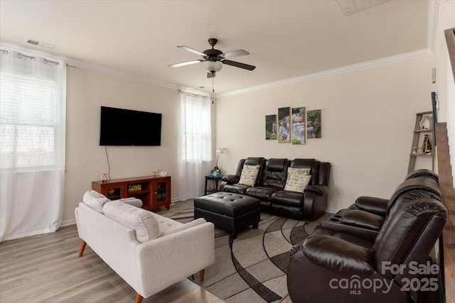 living room featuring crown molding, light hardwood / wood-style floors, and ceiling fan