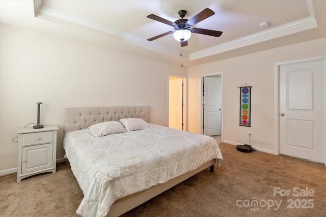 carpeted bedroom featuring crown molding, a tray ceiling, and ceiling fan