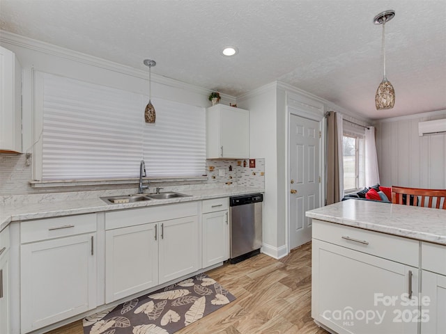 kitchen with sink, white cabinets, a textured ceiling, decorative light fixtures, and stainless steel dishwasher