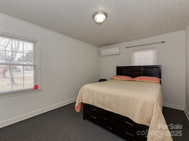 bedroom with an AC wall unit, dark carpet, and a textured ceiling