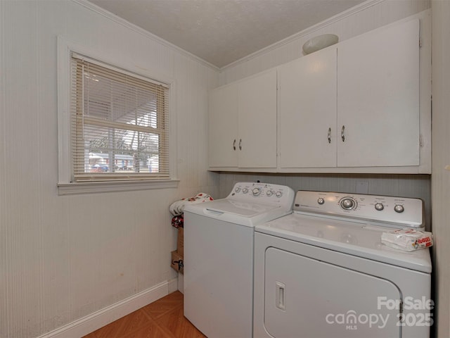 washroom featuring cabinets, light parquet floors, washing machine and clothes dryer, crown molding, and a textured ceiling