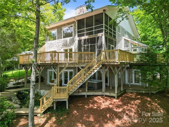 back of house featuring a sunroom, ceiling fan, and a deck