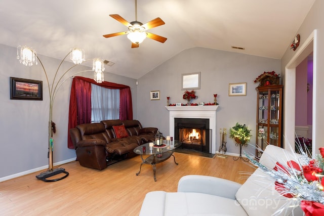 living room with wood-type flooring, ceiling fan, and vaulted ceiling