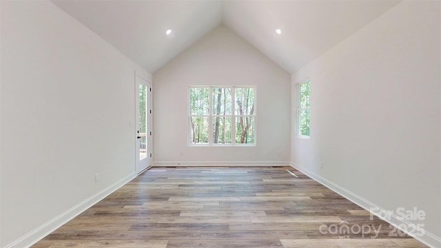 empty room with a wealth of natural light, wood finished floors, and recessed lighting