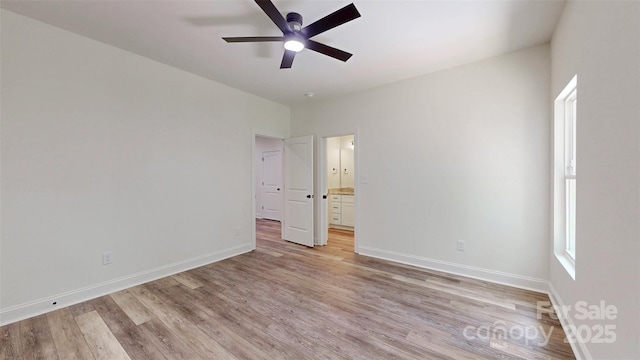 unfurnished bedroom with connected bathroom, baseboards, a ceiling fan, and light wood-style floors