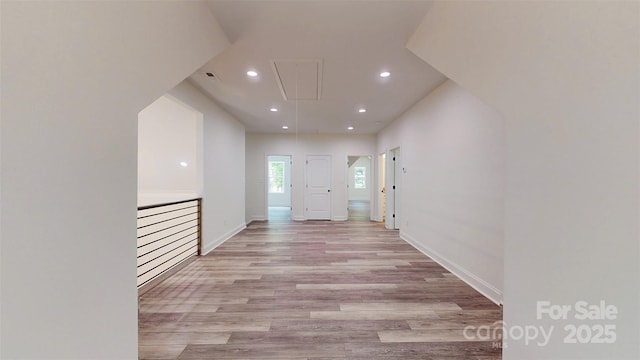 corridor with baseboards, attic access, recessed lighting, and light wood-style flooring