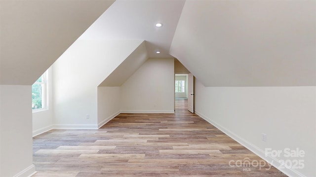 additional living space with vaulted ceiling, light wood finished floors, baseboards, and recessed lighting