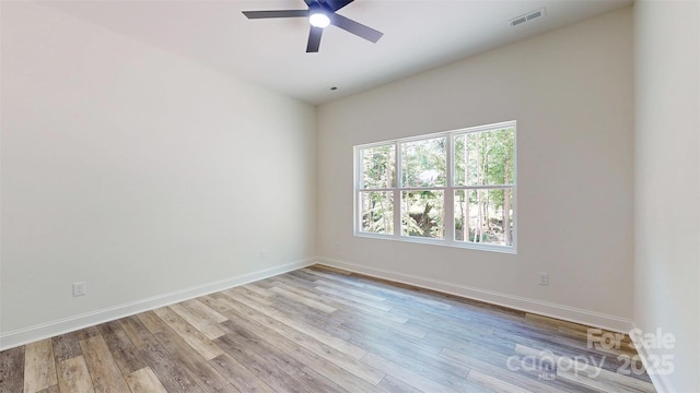 spare room featuring baseboards, ceiling fan, visible vents, and wood finished floors