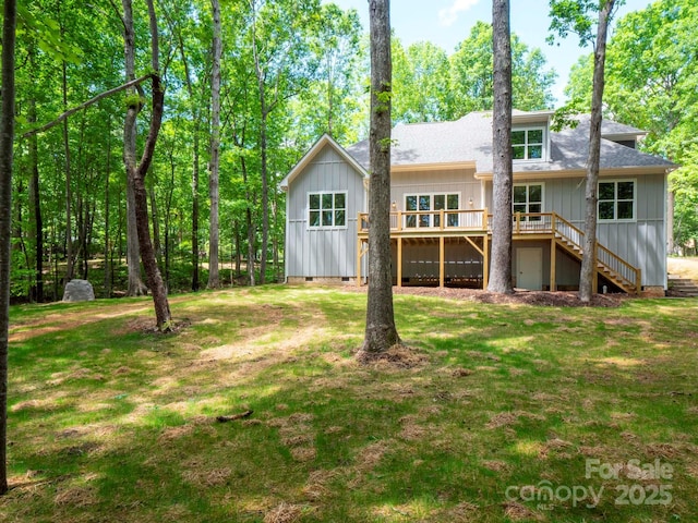 rear view of house featuring a lawn, board and batten siding, stairs, crawl space, and a wooden deck