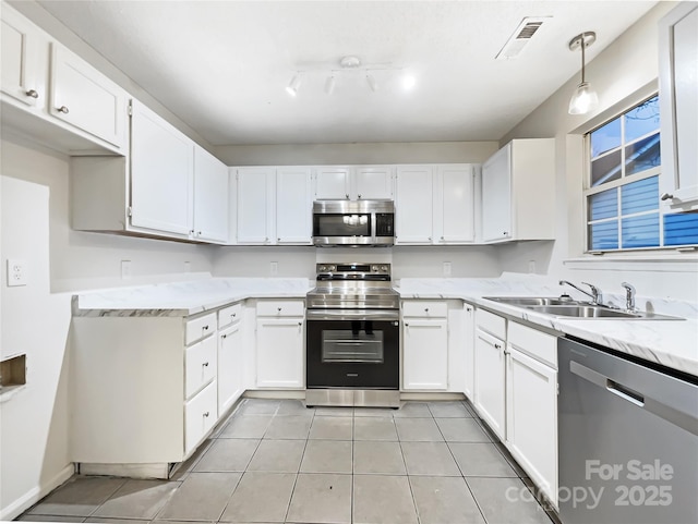 kitchen with appliances with stainless steel finishes, sink, hanging light fixtures, and white cabinets