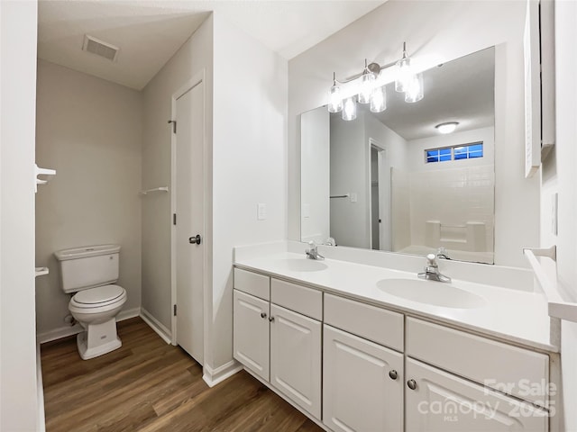 bathroom featuring vanity, wood-type flooring, and toilet