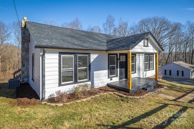 view of front of home with a front lawn and central air condition unit