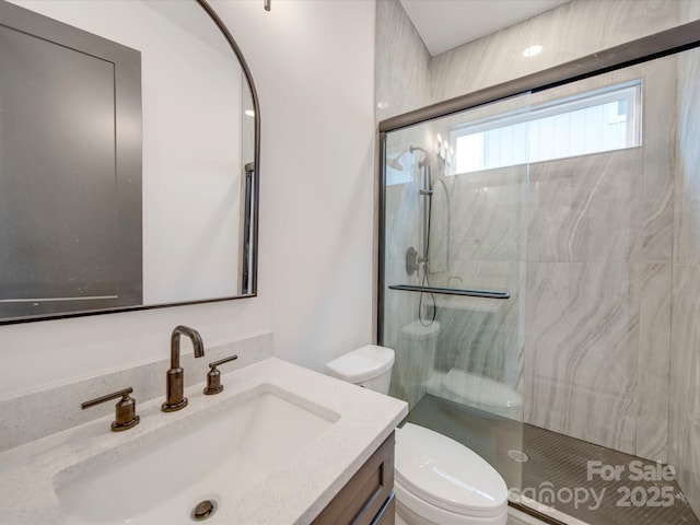 bathroom with vanity, toilet, and a shower with door