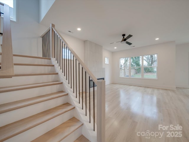 stairway with hardwood / wood-style flooring and ceiling fan