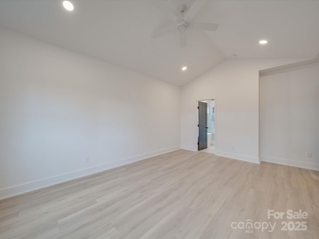 empty room with ceiling fan, lofted ceiling, and light hardwood / wood-style floors