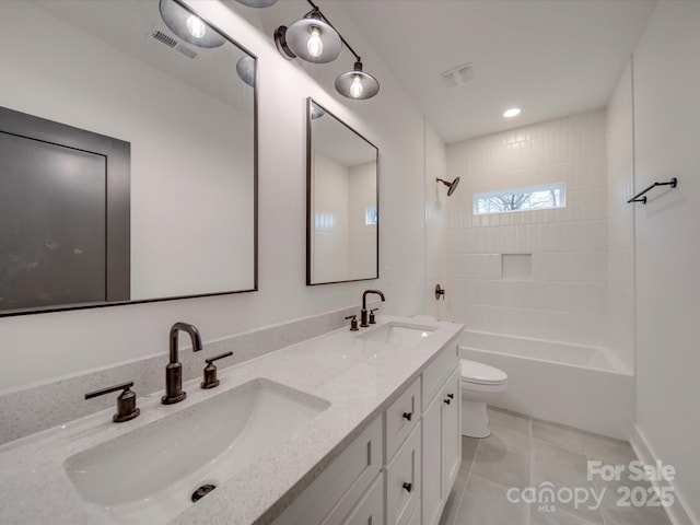 full bathroom featuring tile patterned flooring, tiled shower / bath, vanity, and toilet