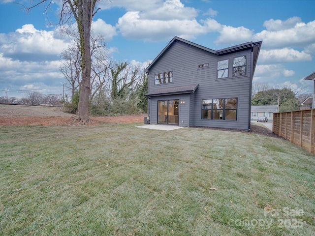 back of house featuring a lawn and a patio area