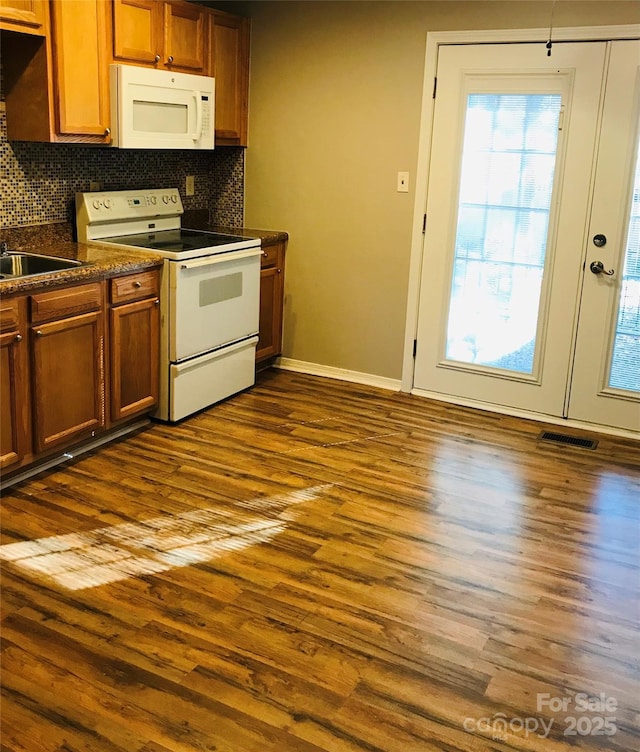 kitchen featuring tasteful backsplash, dark hardwood / wood-style floors, and white appliances