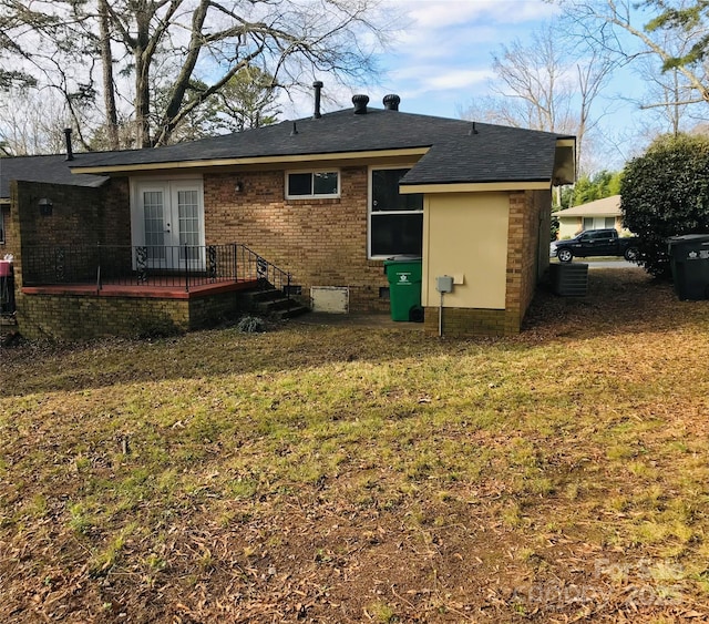 back of property featuring french doors, a yard, and central AC